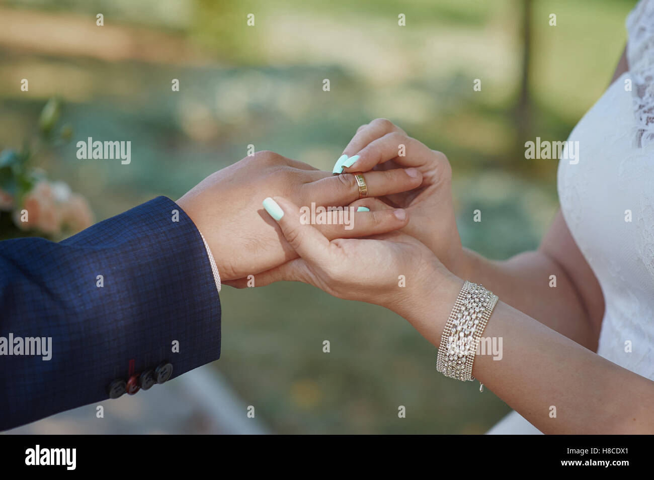 bride wears a wedding ring on the finger of groom Stock Photo Alamy
