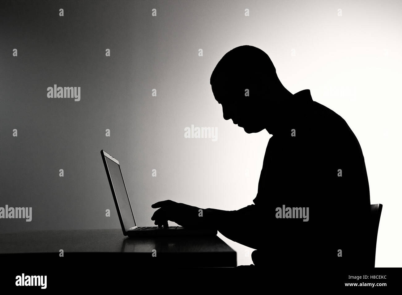 hacker criminal dark web code malware exploit ddos attack infect silhouette contrast Stock Photo