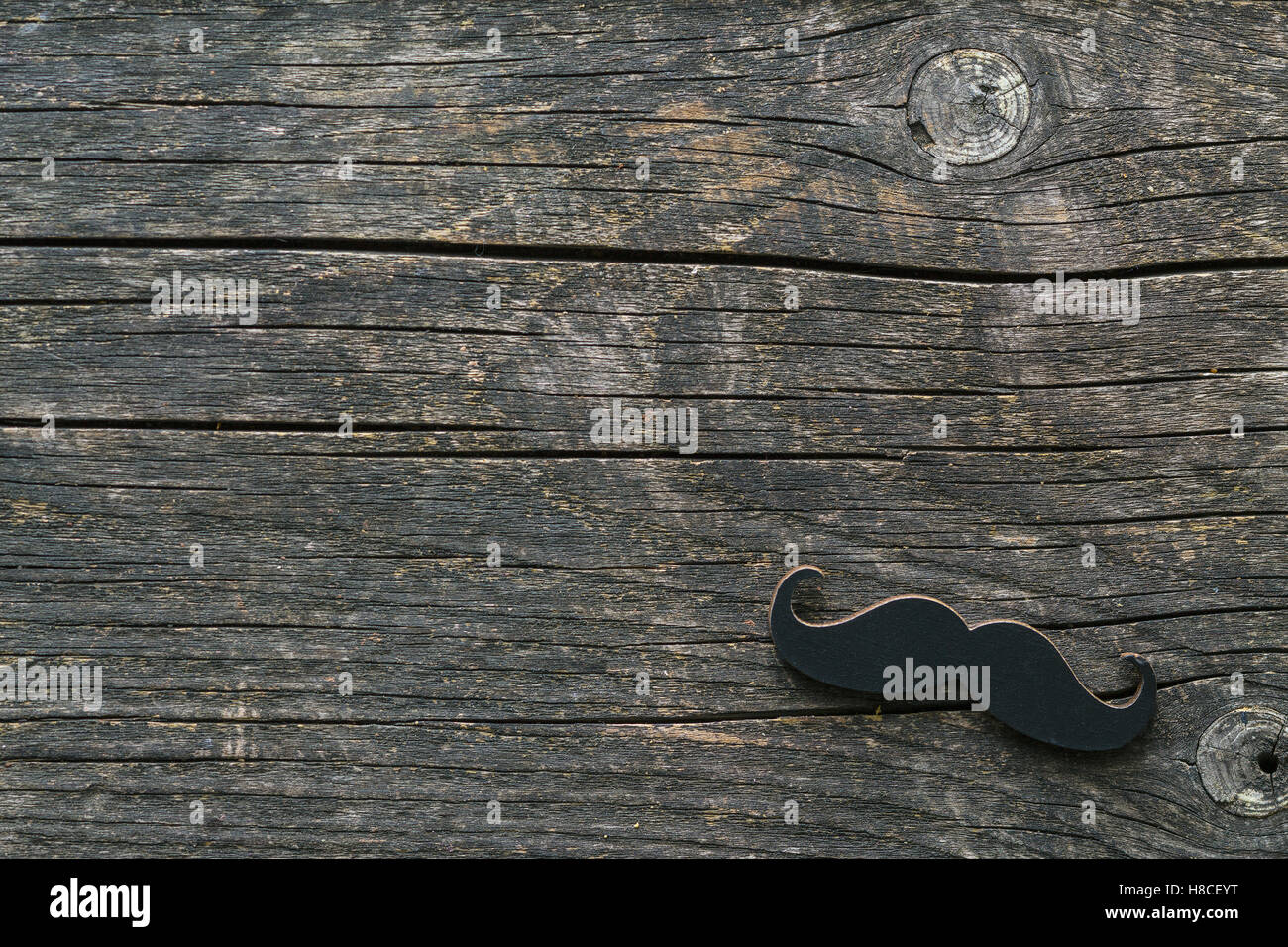Fake black mustache on wooden background. Stock Photo