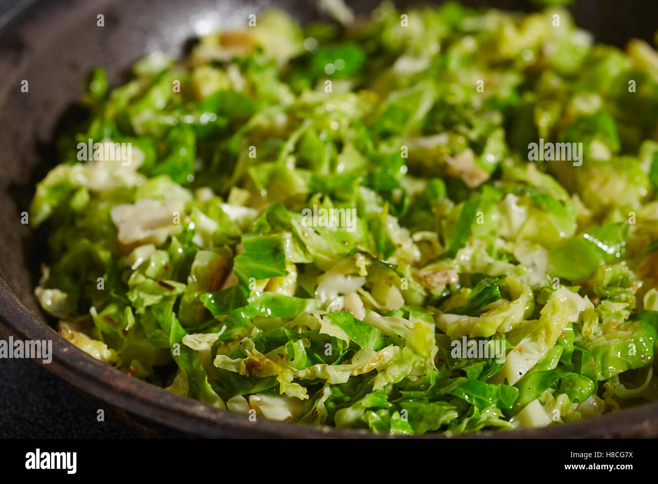 sliced brussels sprouts frying in a skillet Stock Photo
