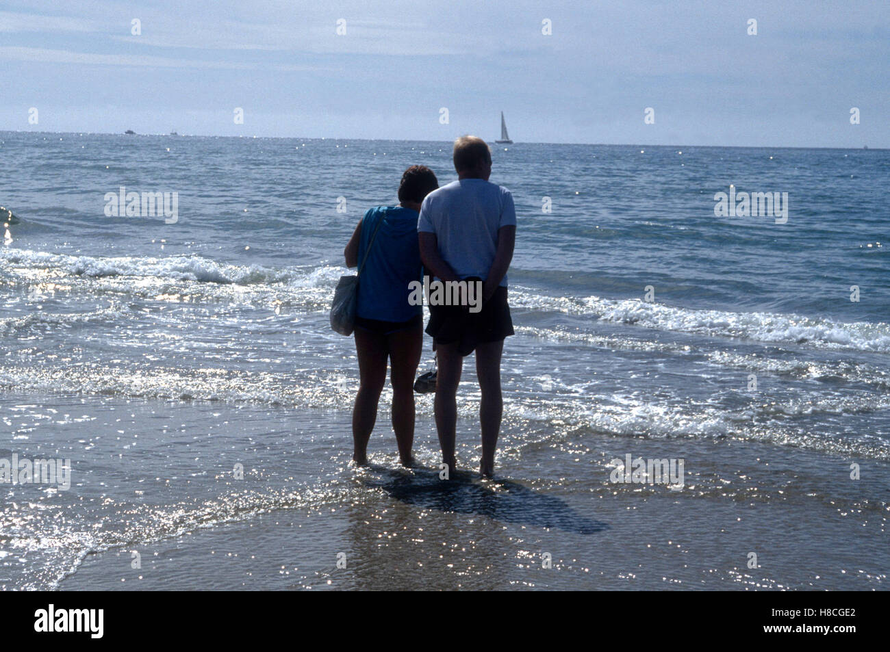 A couple standing in the water on the cape of Skagen where two Oceans meet Stock Photo
