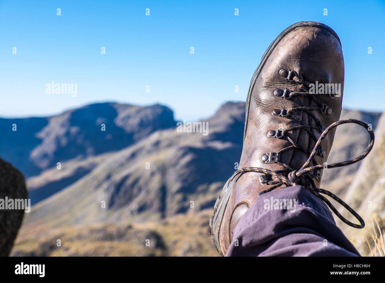 A hillwalker's boot in the foreground with Scafell in the distance Stock Photo