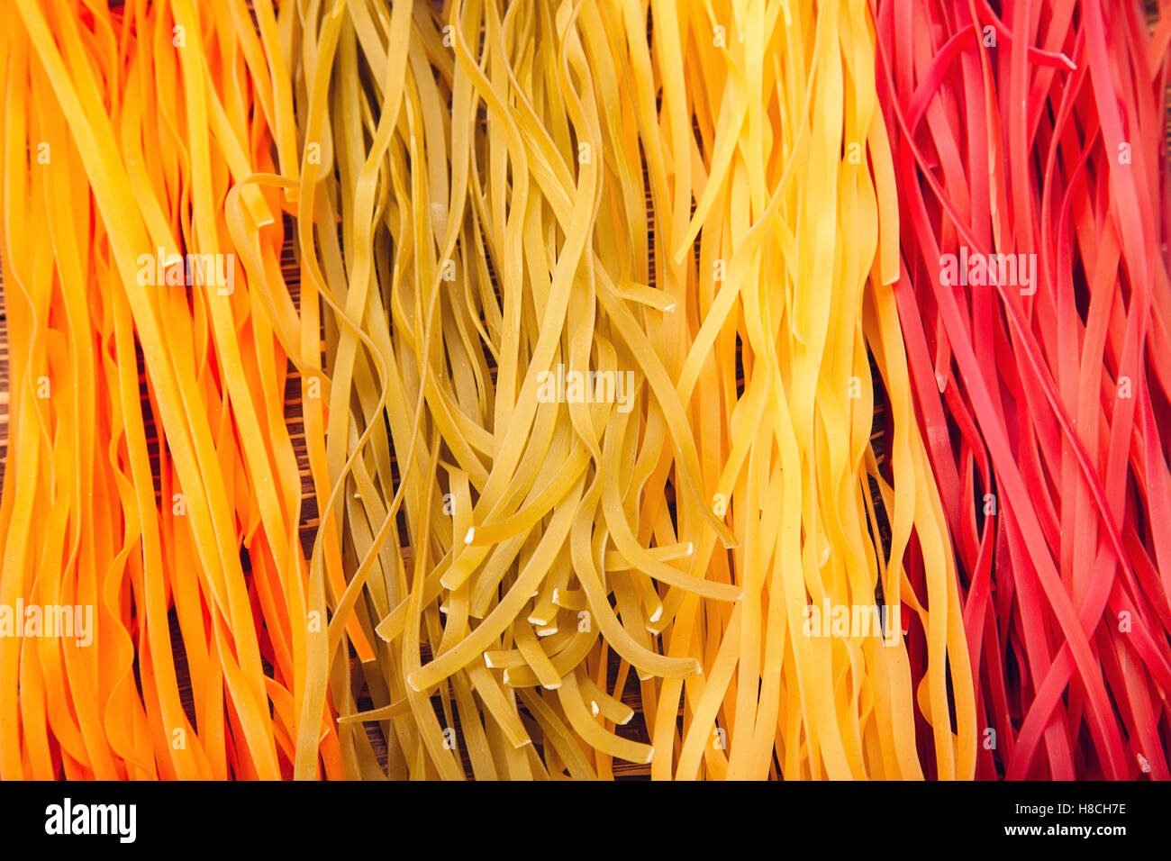 Colourful Italian pasta tagliatelle made from traditional recipe on retro wooden background Stock Photo