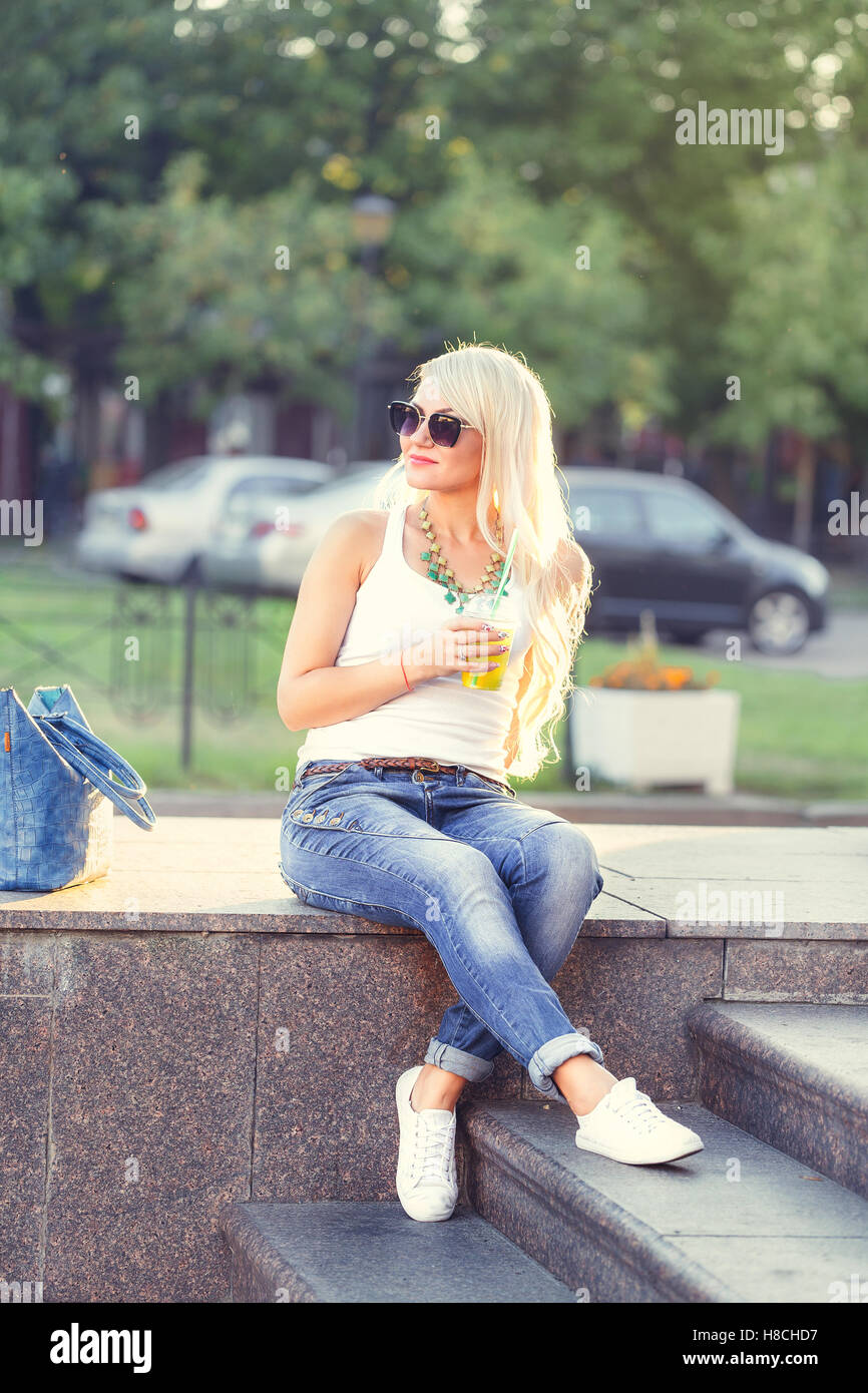 beautiful young woman sitting and drinking fresh mojito outdoor Stock Photo