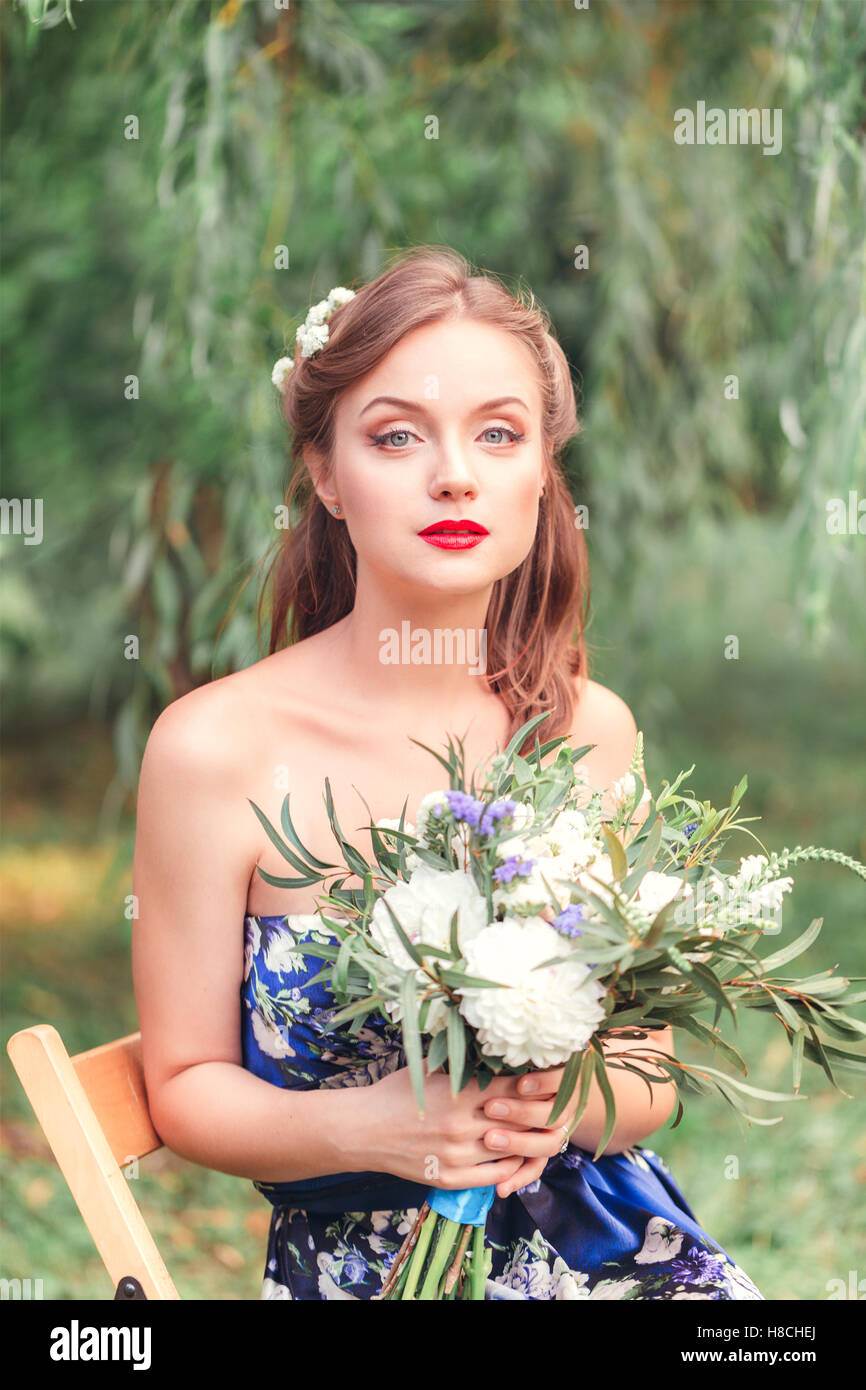 beautiful young woman with a bouquet of flowers in their hands looking ...