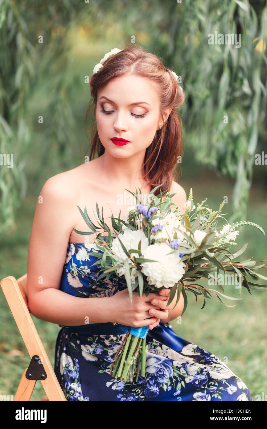 beautiful young woman with a bouquet of flowers in their hands looking ...