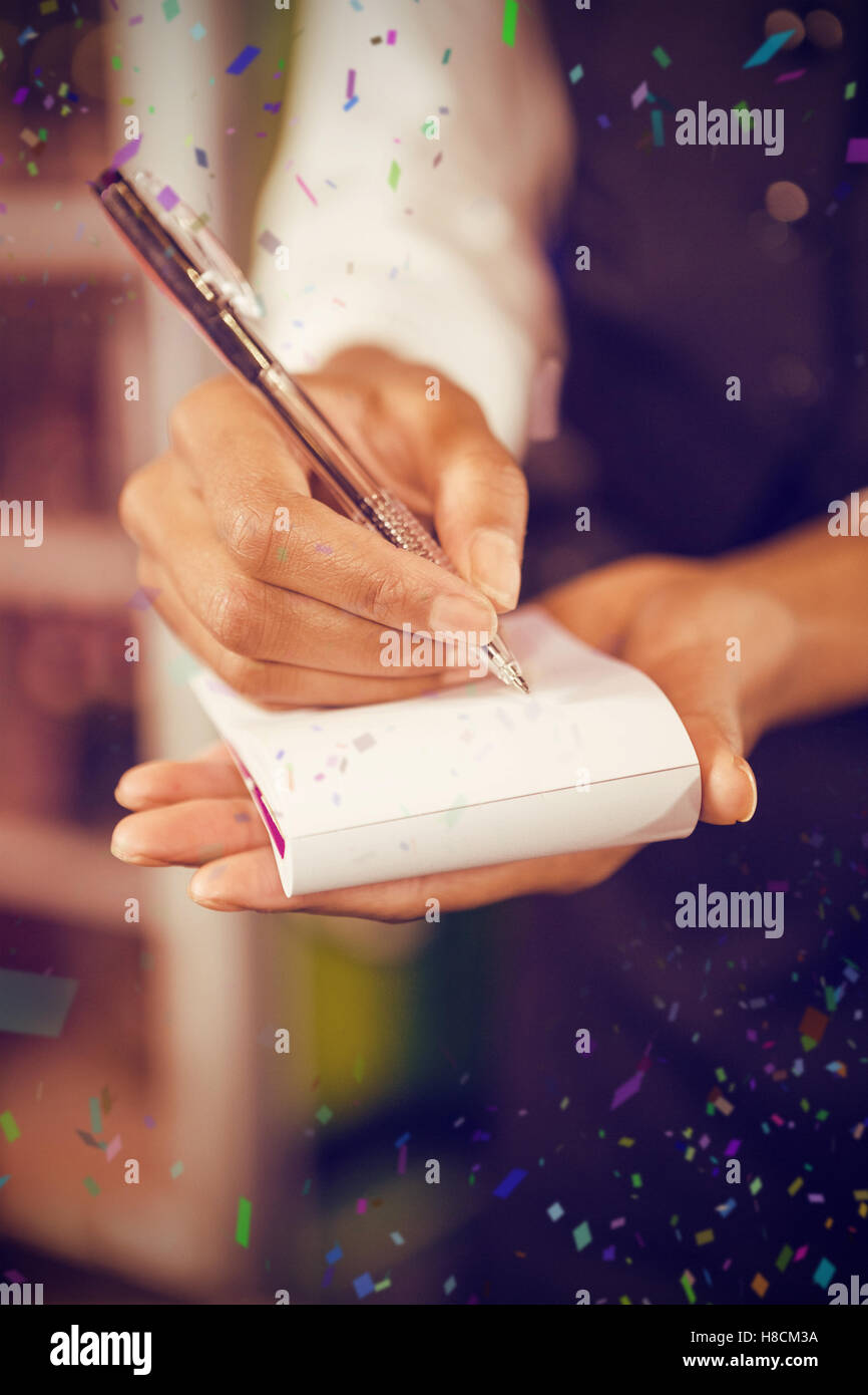 Composite image of midsection of waiter writing down an order Stock Photo