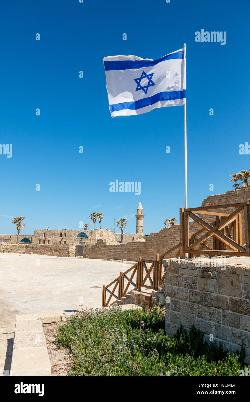 ancient remnants of Ceasarea  and waving flag of Israel in  Maritima National Park in Caesarea, Israel. Stock Photo
