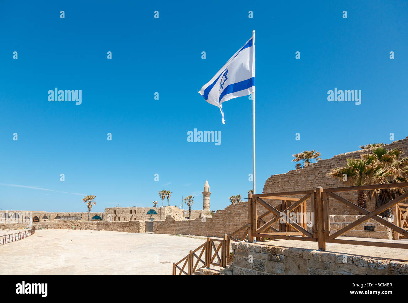ancient remnants of Ceasarea  and waving flag of Israel in  Maritima National Park in Caesarea, Israel. Stock Photo