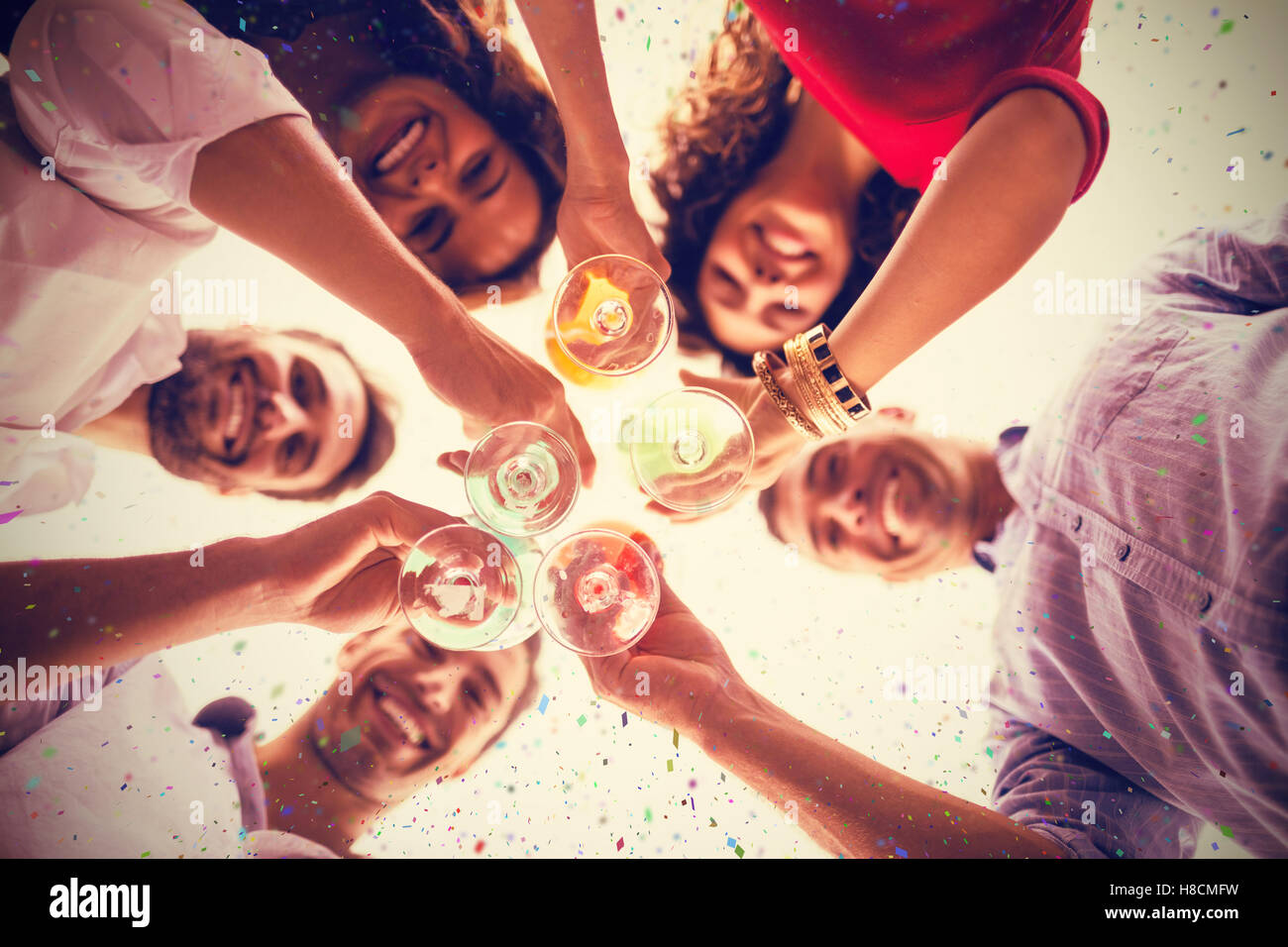 Composite image of directly below shot of friends having cocktail while standing Stock Photo