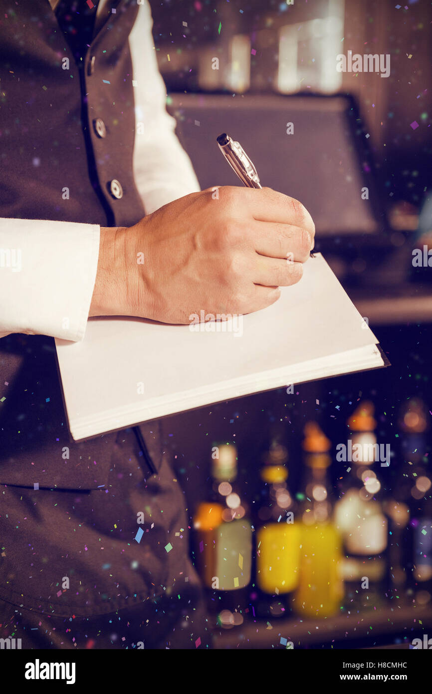 Composite image of bartender writing down an order Stock Photo
