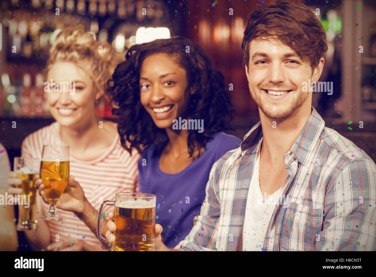 Composite image of portrait of cheerful friends having beer Stock Photo
