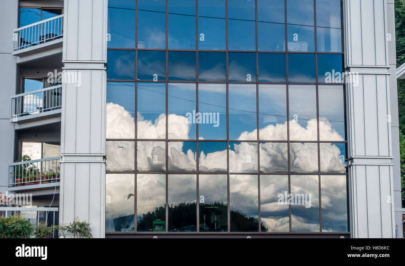 Billowing clouds are reflected in the windows of a West Seattle building. Stock Photo