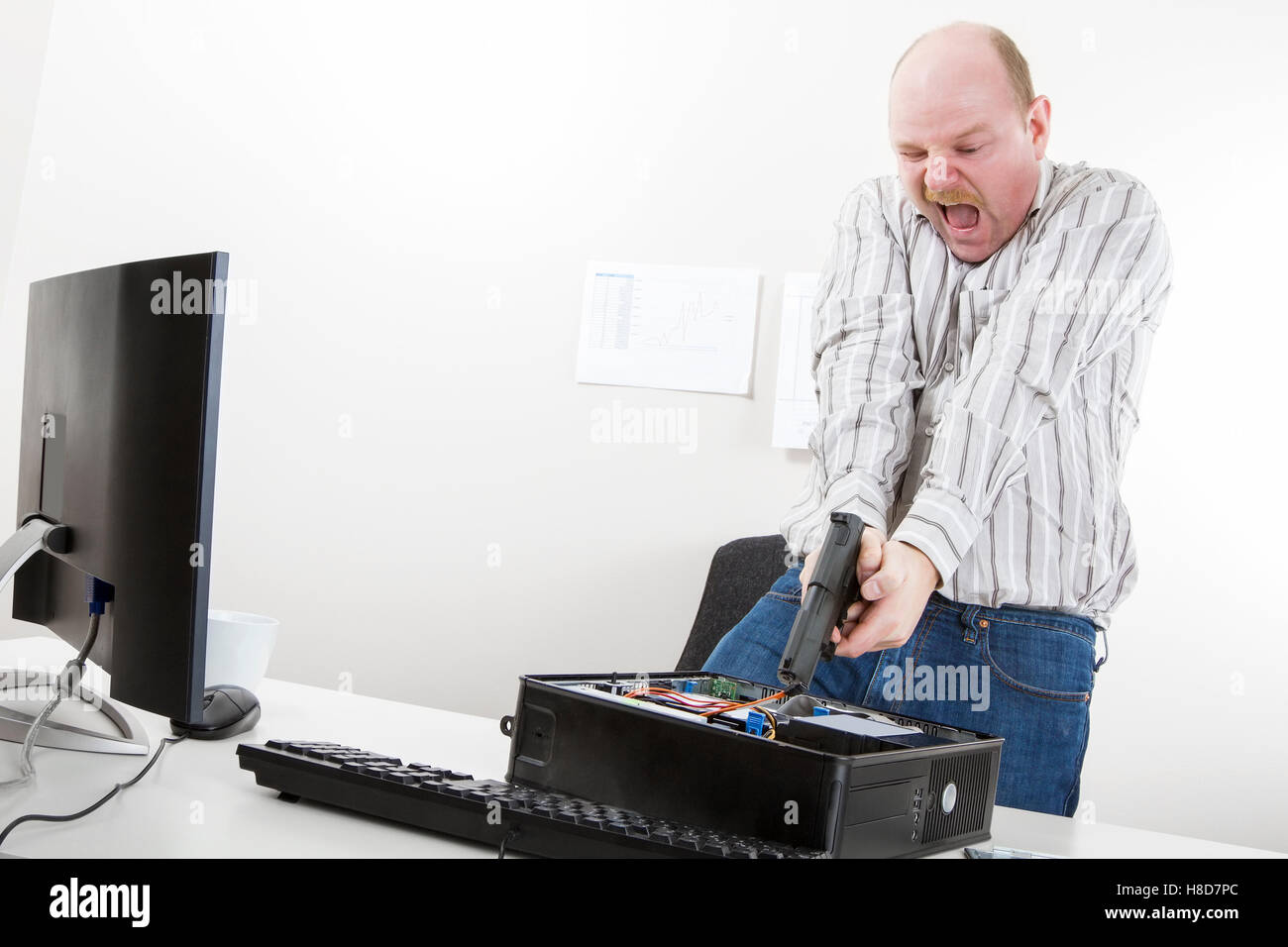 Businessman Aiming Gun On CPU At Desk Stock Photo