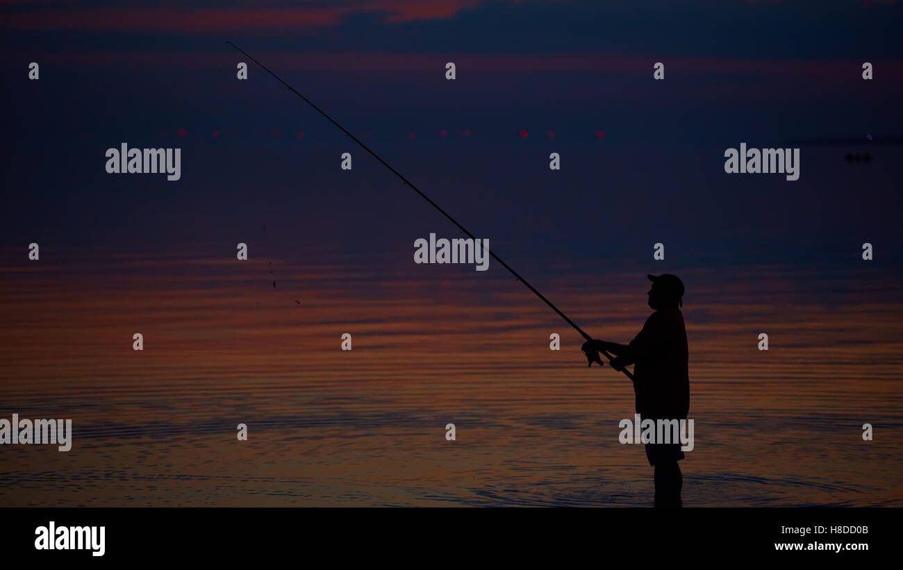 Silhouette of fishermen on quiet ocean with rays sunset Stock Photo - Alamy