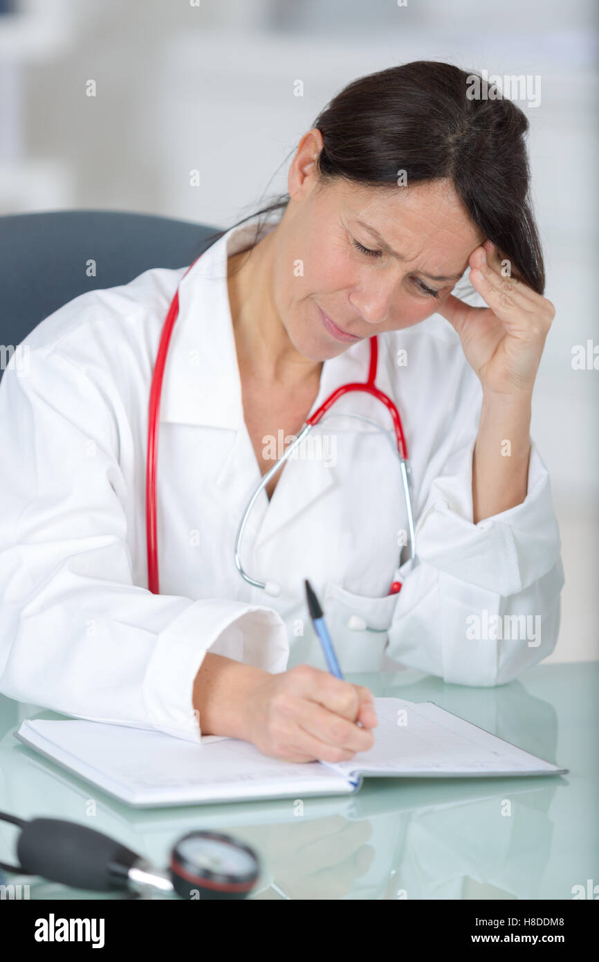 thoughtful woman doctor reviewing patients state Stock Photo