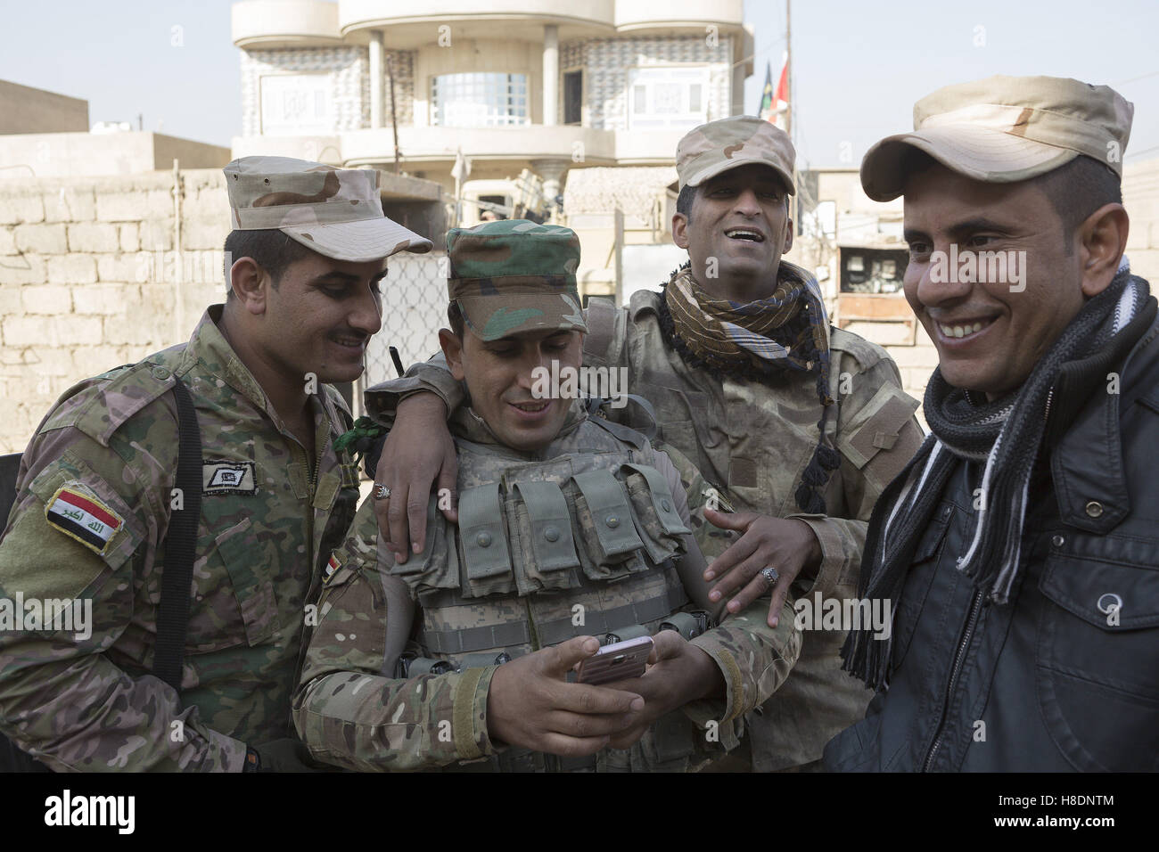 Mosul, Nineveh, Iraq. 11th Nov, 2016. 11/11/2016. Mosul, Iraq. Soldiers, belonging to the Iraqi Army's 9th Armoured Division, relax during a visit to Mosul's Hay Intisar district on the south east of the city. The district was taken by Iraqi Security Forces (ISF) around a week ago and, despite its proximity to ongoing fighting between ISF and ISIS militants, many residents still live in the settlement. Credit:  ZUMA Press, Inc./Alamy Live News Stock Photo