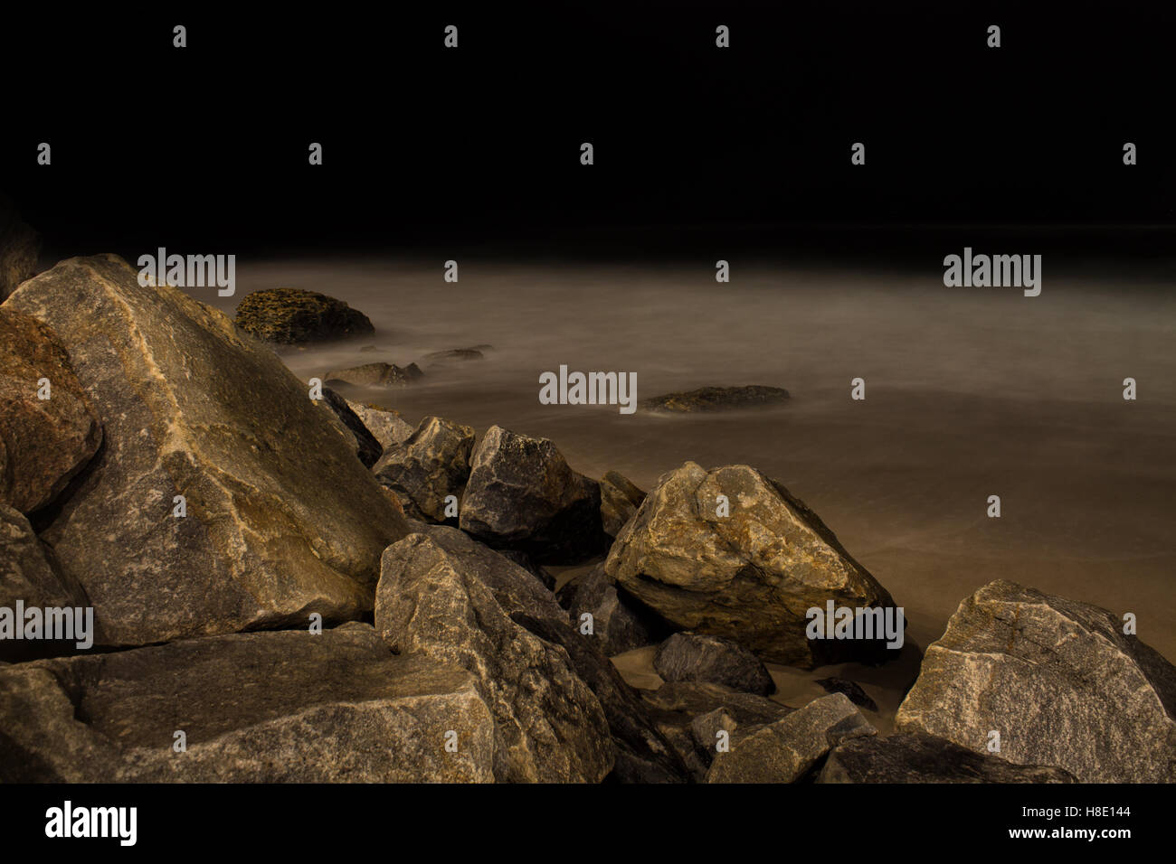 Coastal ocean rocks in a dark with black night sky.Long exposure shot ...