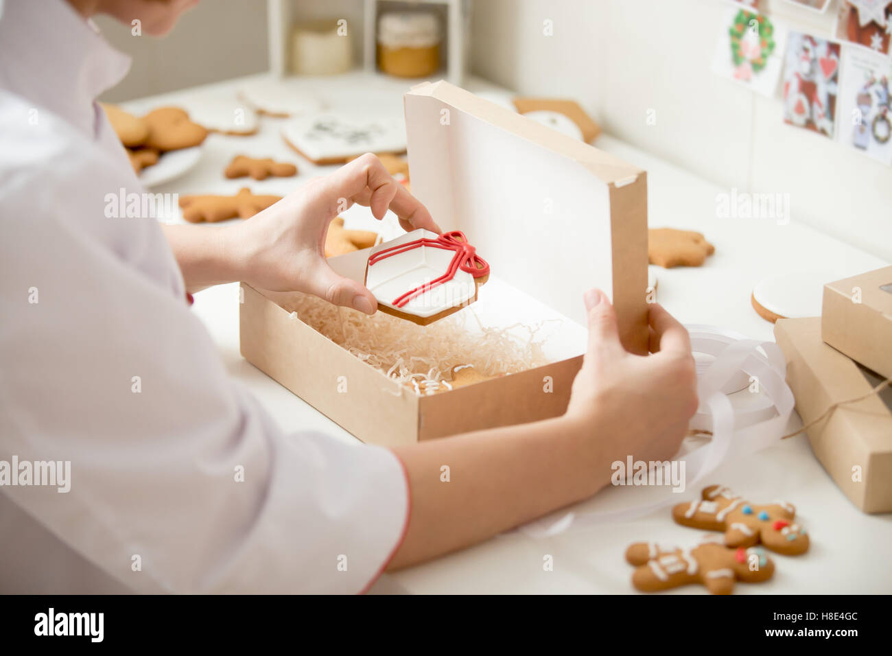 Process of packing gingerbread cookies into a kraft box Stock Photo