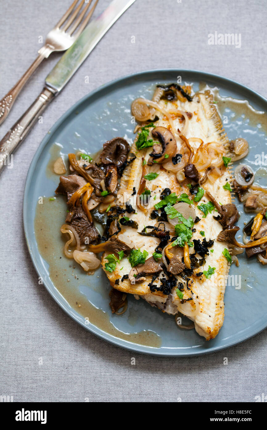 Hot soused Dover sole with wild mushrooms, shallots and seaweed flakes Stock Photo