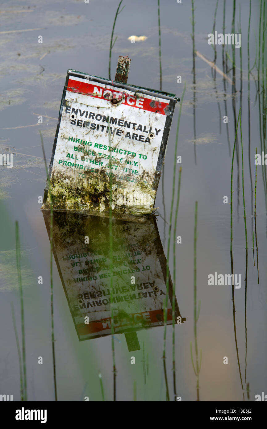 Environment protection sign submerged in a natural pond, Ontario, Canada Stock Photo