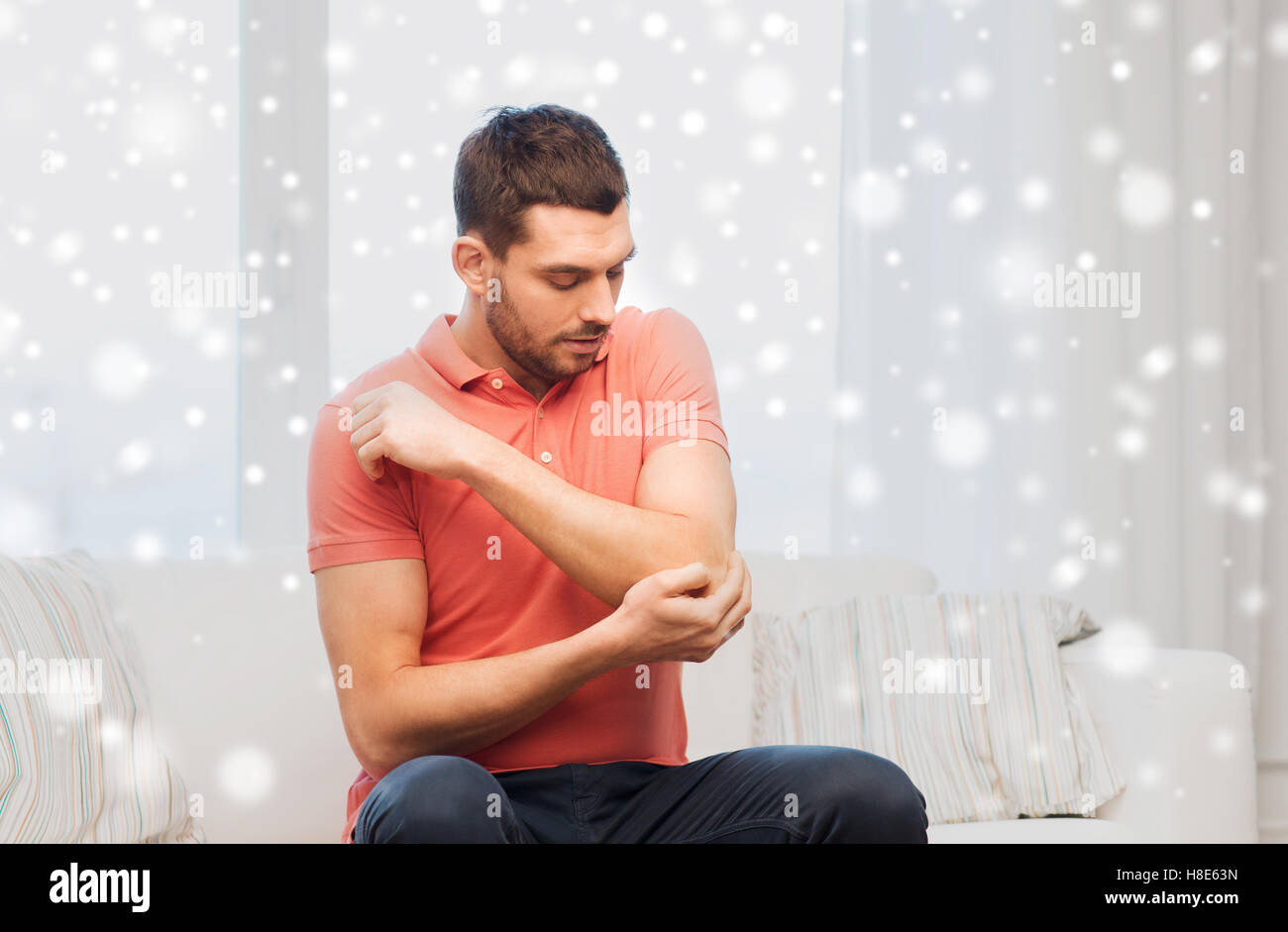 unhappy man suffering from pain in hand at home Stock Photo - Alamy