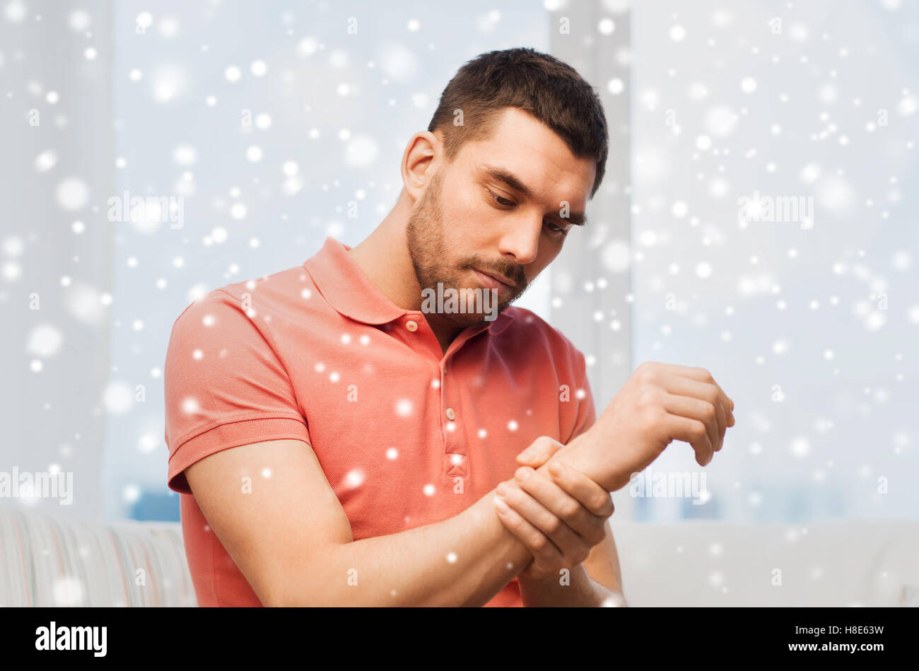 unhappy man suffering from pain in hand at home Stock Photo - Alamy
