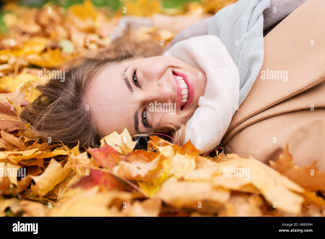 beautiful happy woman lying on autumn leaves Stock Photo - Alamy
