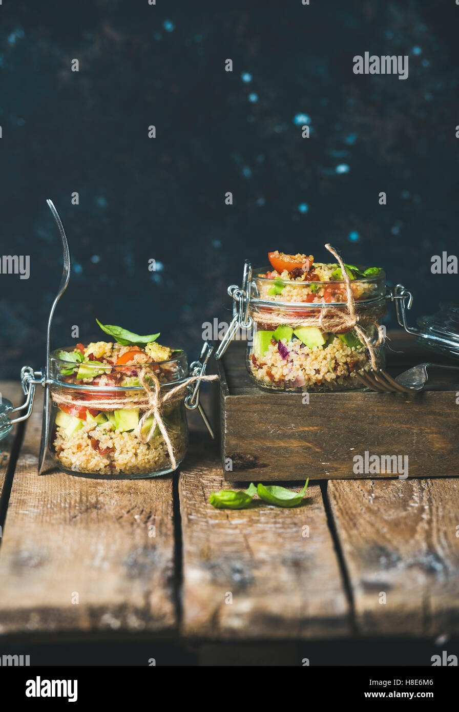 Healthy homemade jar quinoa salad with cherry tomatoes, sun-dried tomatoes, avocado and basil. Detox, dieting, vegetarian, vegan Stock Photo