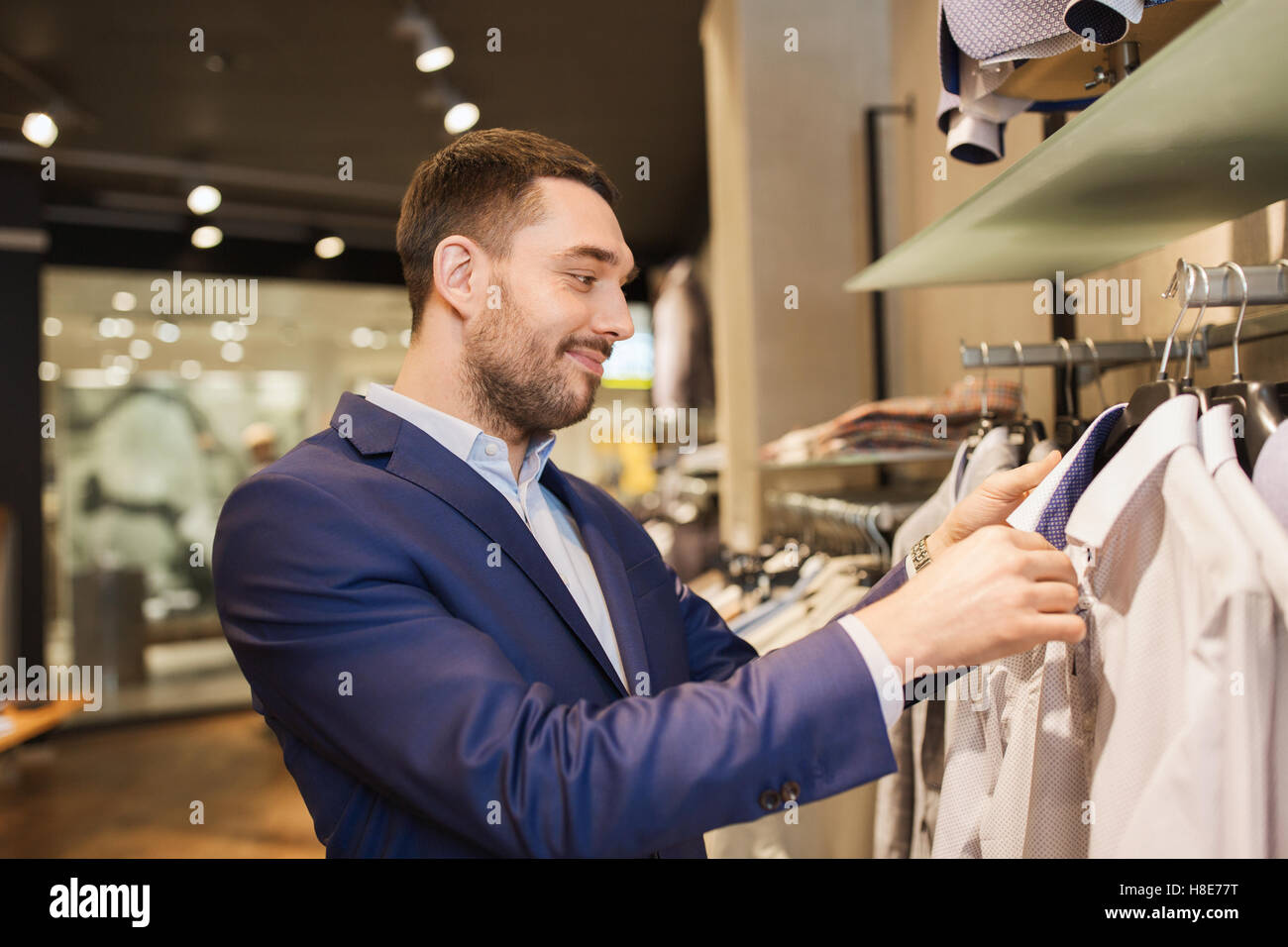 happy young man choosing clothes in clothing store Stock Photo - Alamy