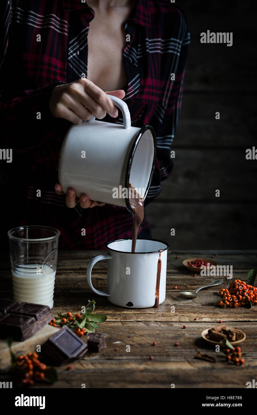 Woman pouring hot chocolate in a mug Stock Photo