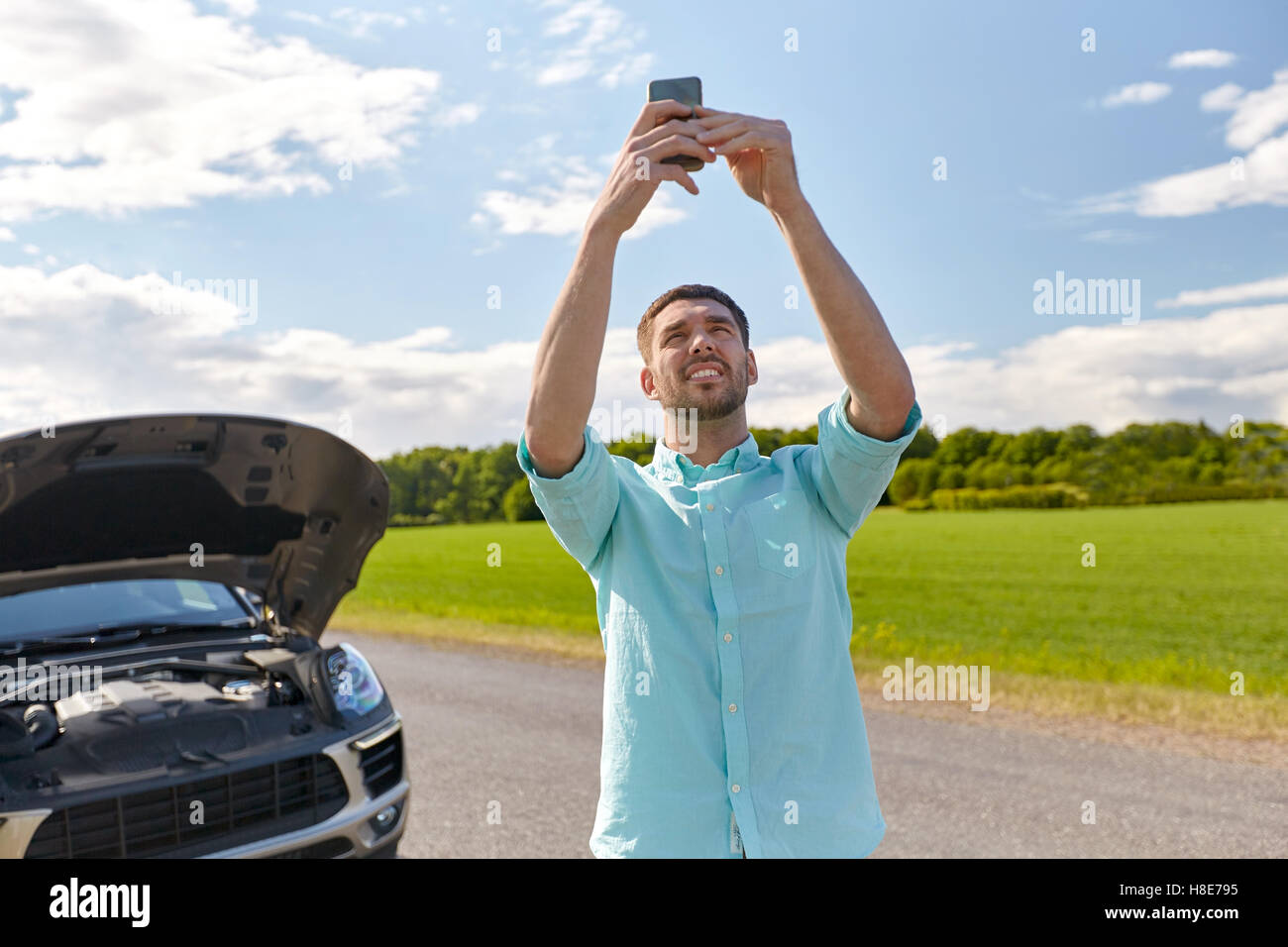 man with smartphone and broken car at countryside Stock Photo