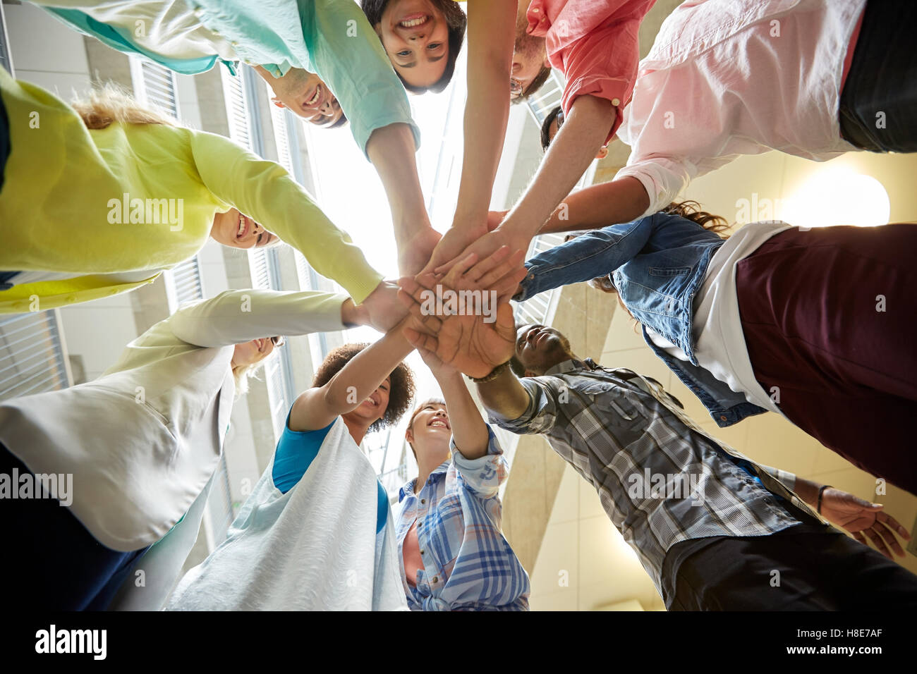 group of international students with hands on top Stock Photo - Alamy