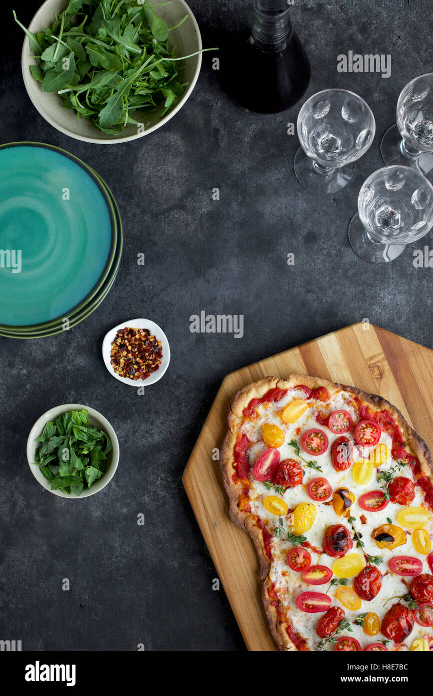 Roasted Tomato Pizza with a thin Olive Oil Cracker Crust. Photographed on black/grey background