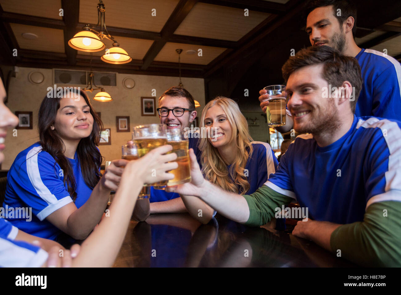 football fans clinking beer glasses at sport bar Stock Photo Alamy