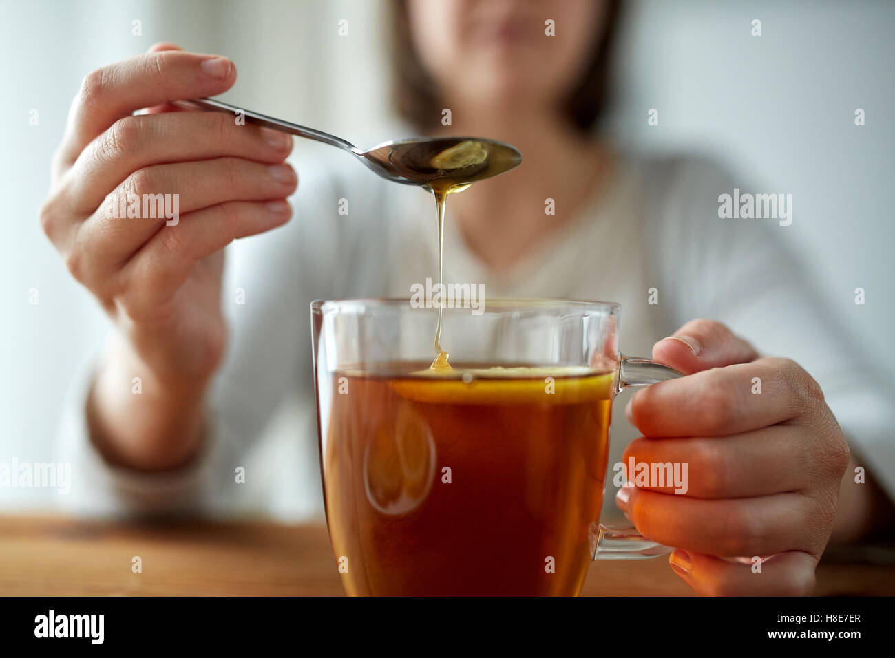 Close Up Of Woman Adding Honey To Tea With Lemon Stock Photo Alamy