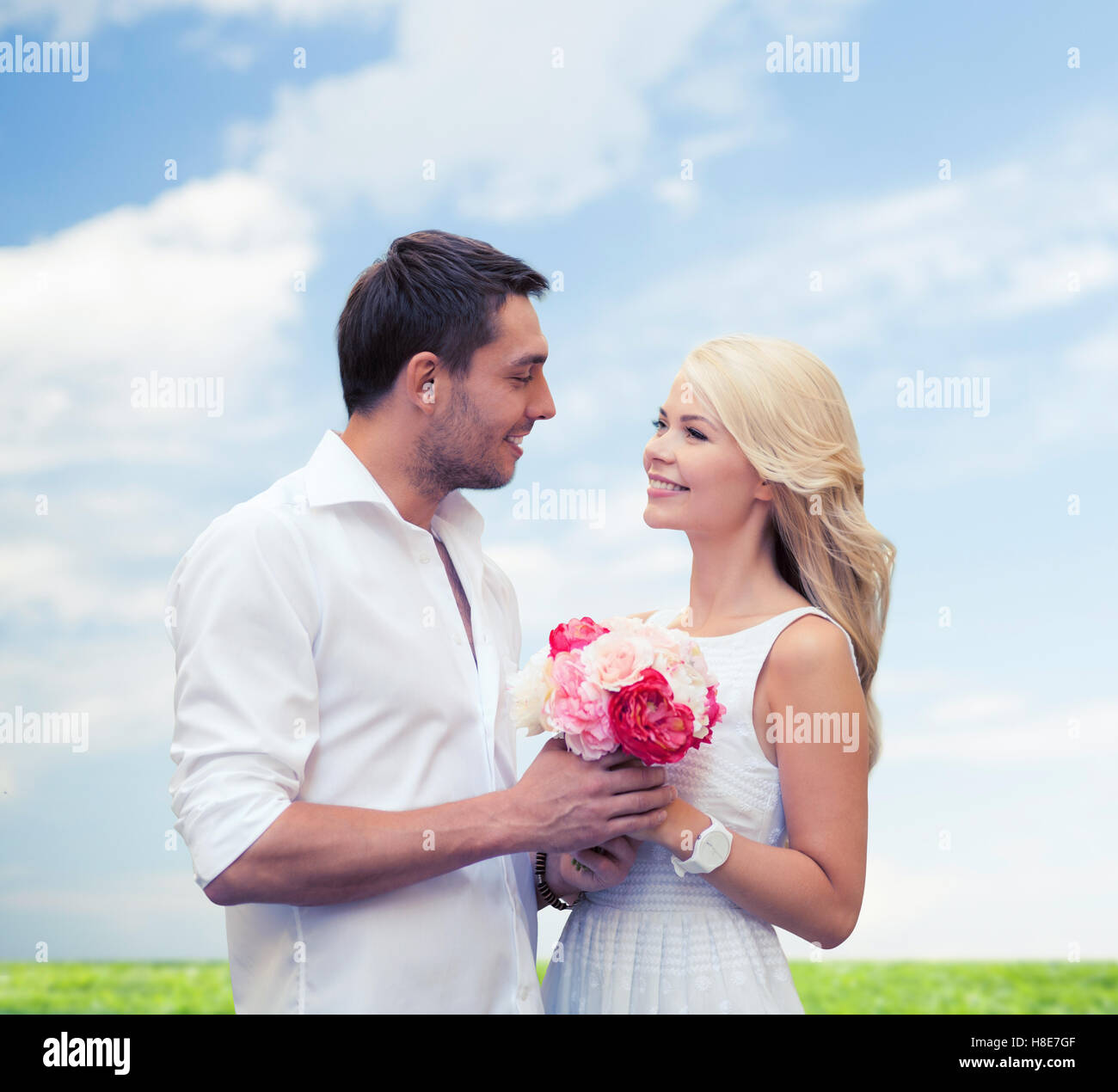 happy couple with flowers over natural background Stock Photo - Alamy