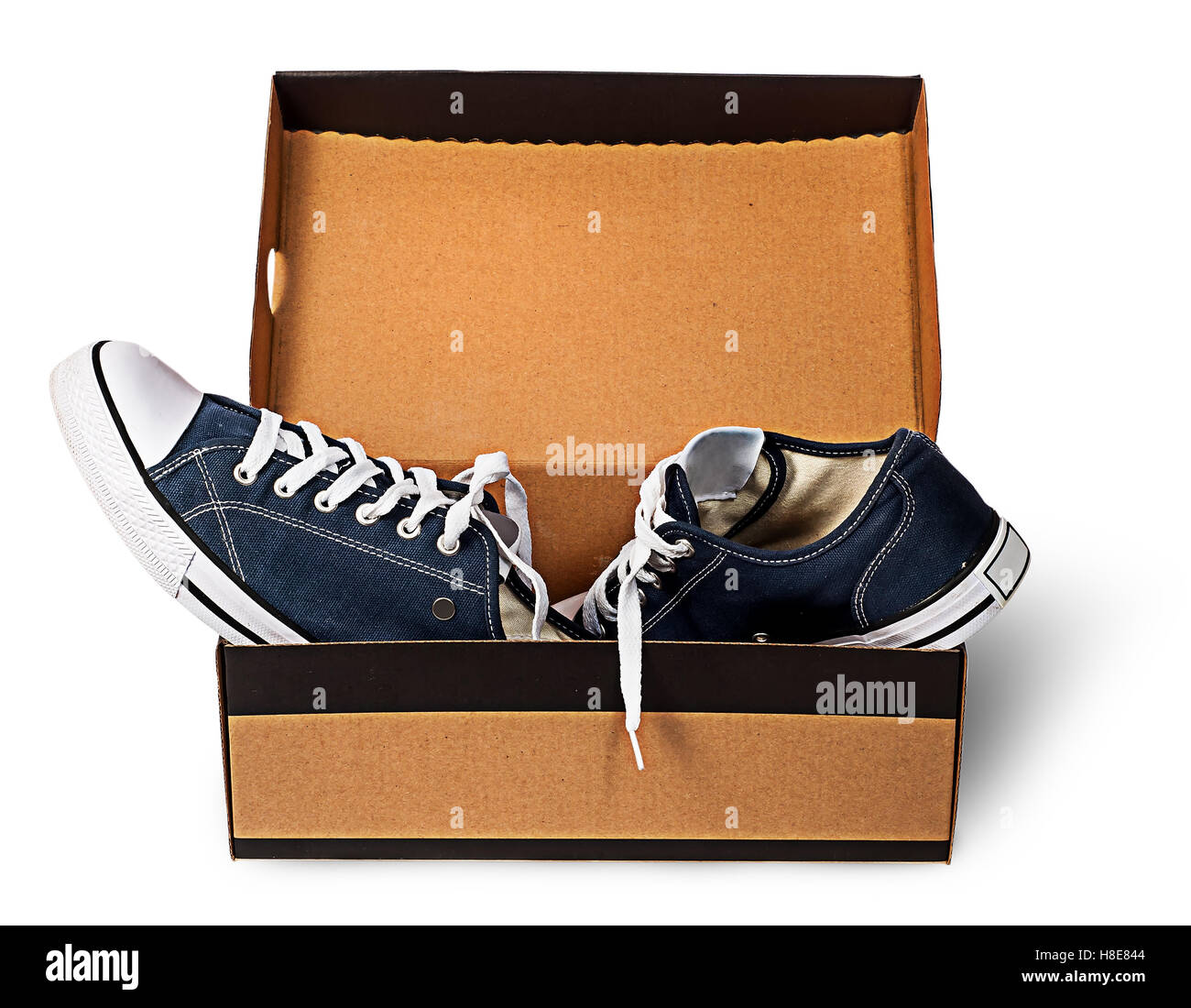 Dark blue sports shoes abandoned in a cardboard box isolated on white background Stock Photo