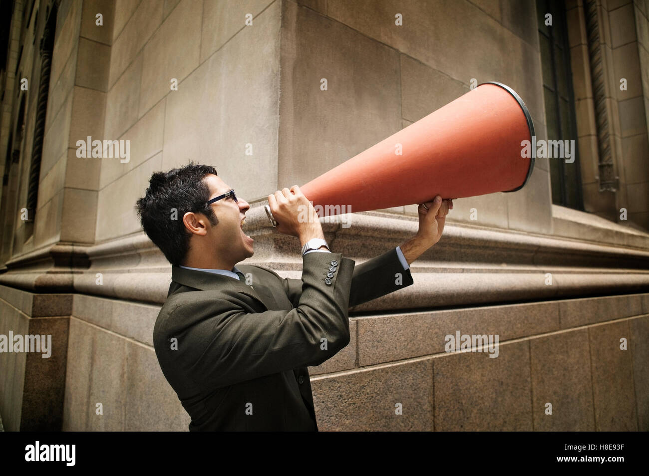 Businessman yelling into a megaphone Stock Photo Alamy