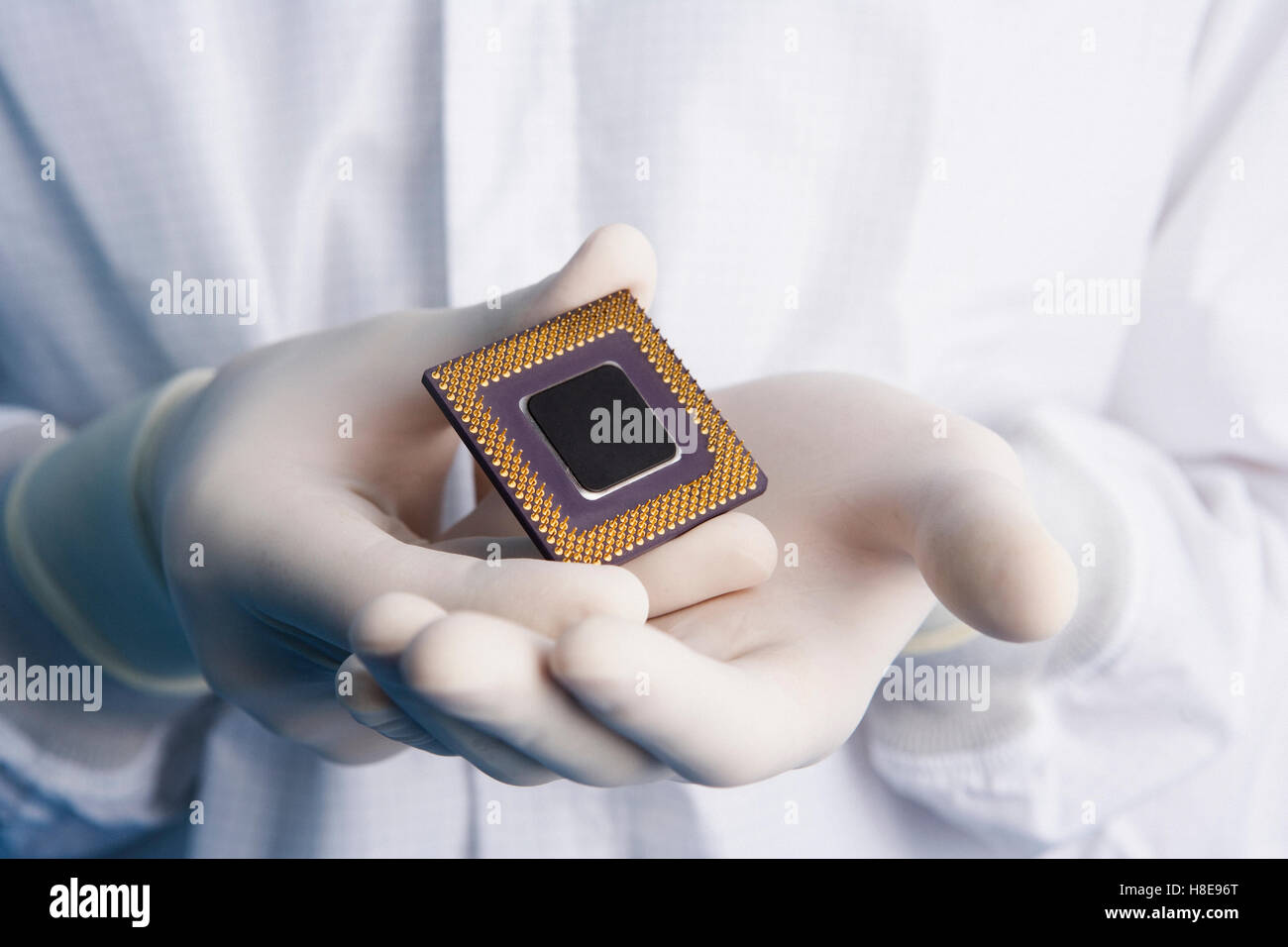 Man in a clean-room suit holding a computer processor Stock Photo