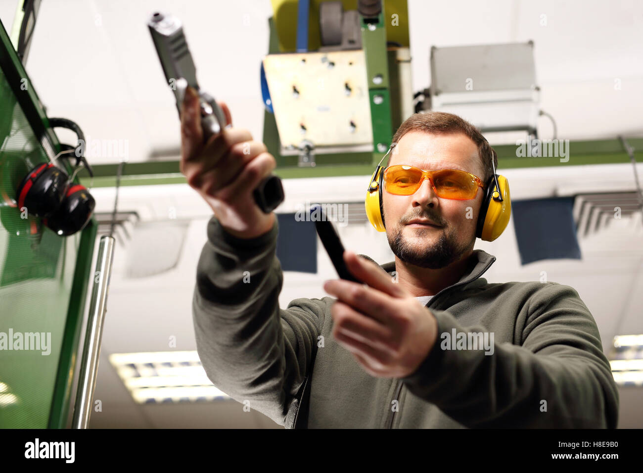 The man at the shooting reloads pistol Stock Photo