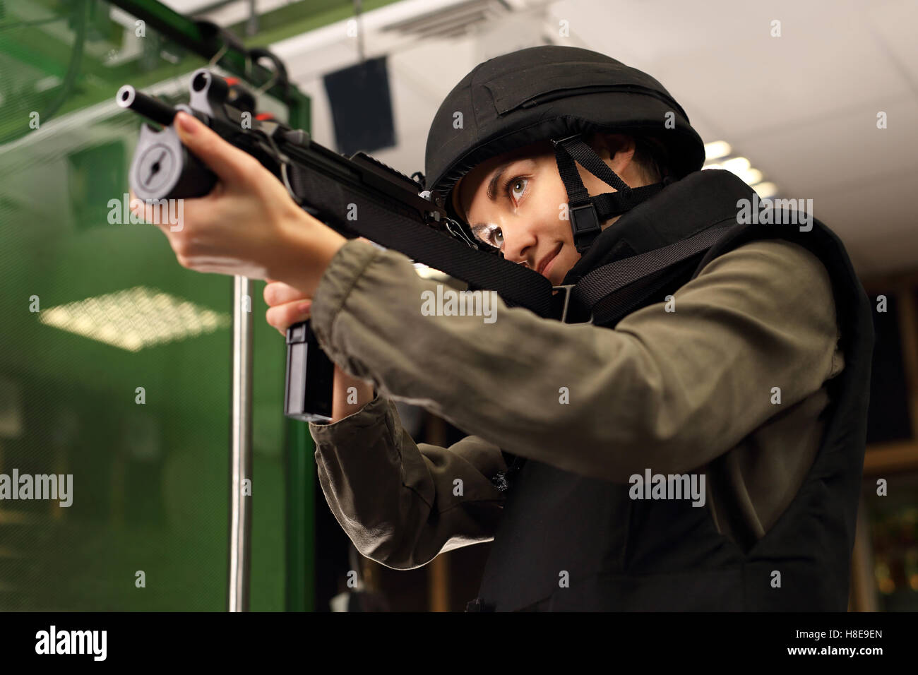 Policewoman at the shooting range with a rifle shot. Woman in vest shot