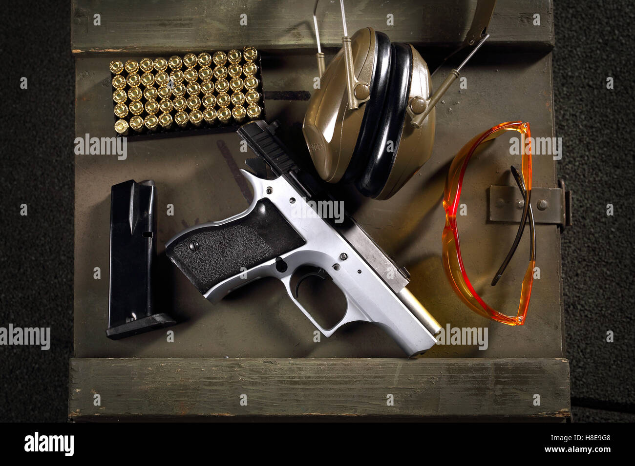 Handgun, pistol. Equipment shooting gun. Gun, cartridges and headphones