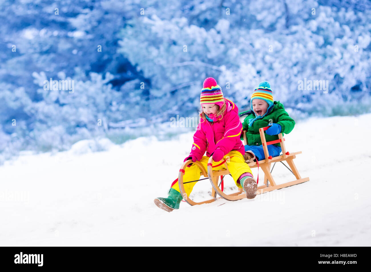 Little girl and boy enjoying sleigh ride. Child sledding. Toddler kid ...