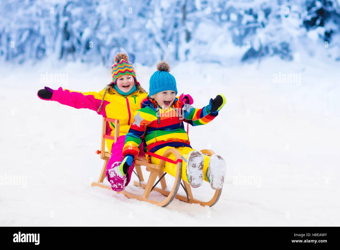 Little girl and boy enjoying sleigh ride. Child sledding. Toddler kid ...