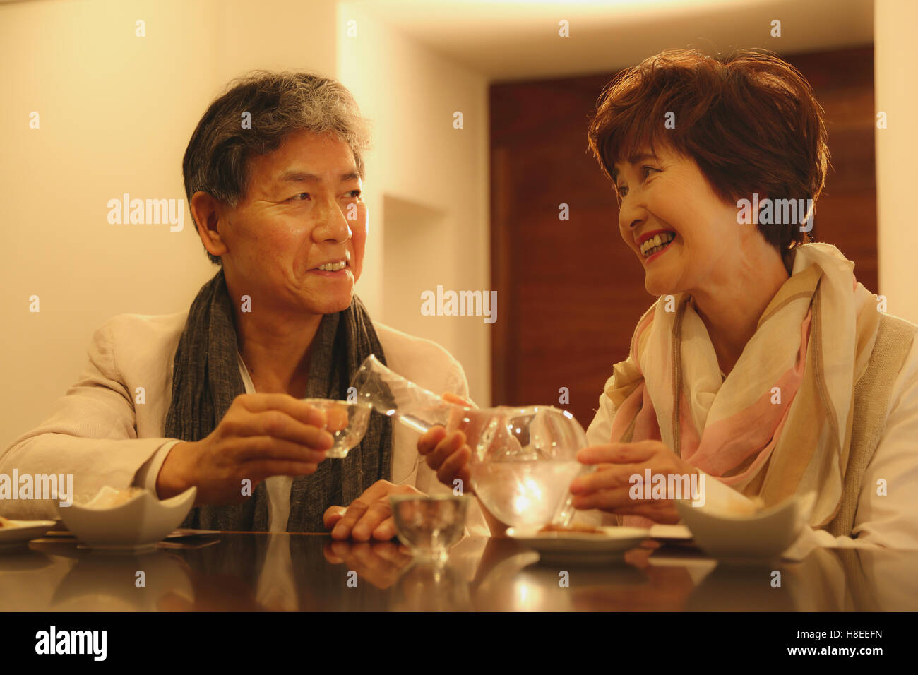 Fashionable Japanese senior couple having a good time at the restaurant Stock Photo