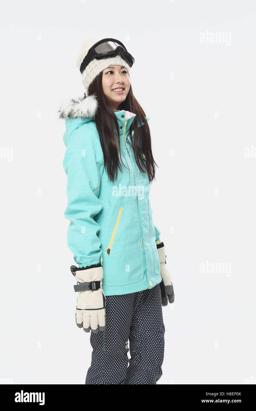 Young Japanese woman wearing snowboard wear on white background Stock