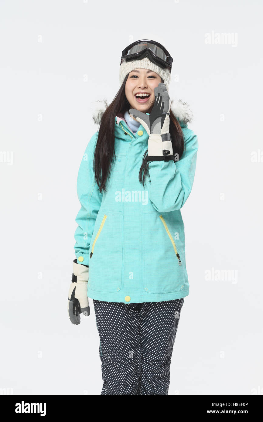 Young Japanese woman wearing snowboard wear on white background Stock