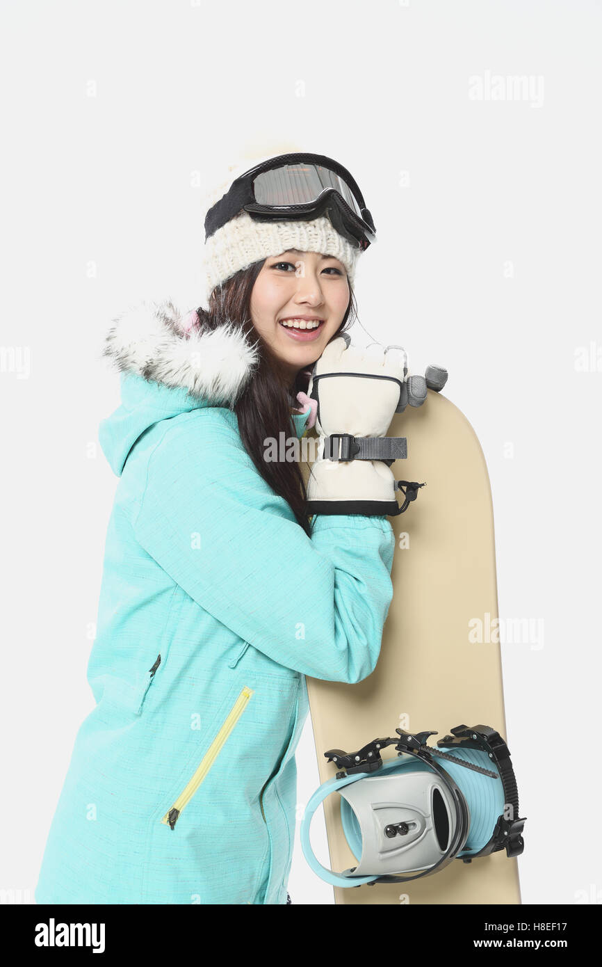 Young Japanese woman wearing snowboard wear on white background Stock