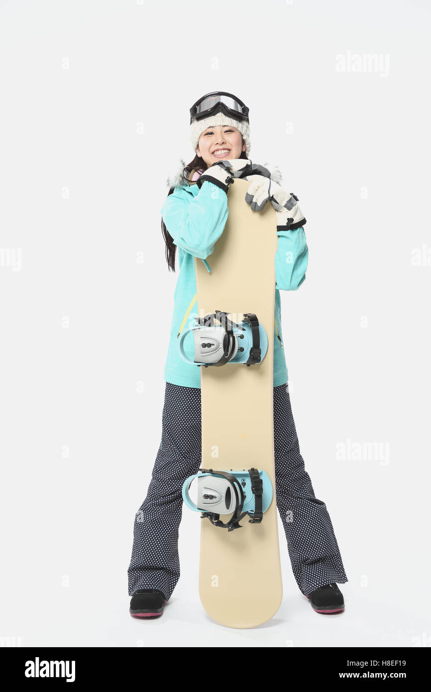 Young Japanese woman wearing snowboard wear on white background Stock